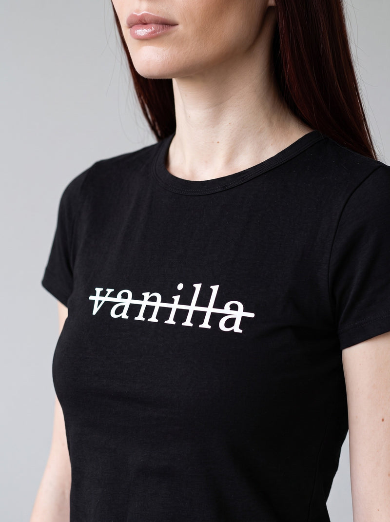Close-up of a black women's tee printed with the word vanilla, struck through.
