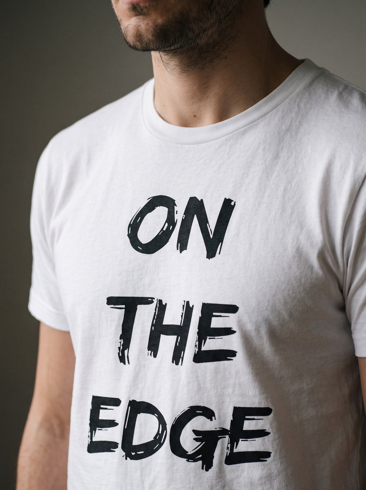 On the Edge tee in White — angled close-up [kk-studio]