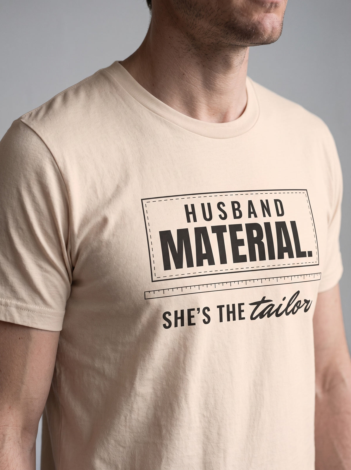 Husband Material. She's the Tailor. tee in Soft Cream — angled close-up [kk-studio]