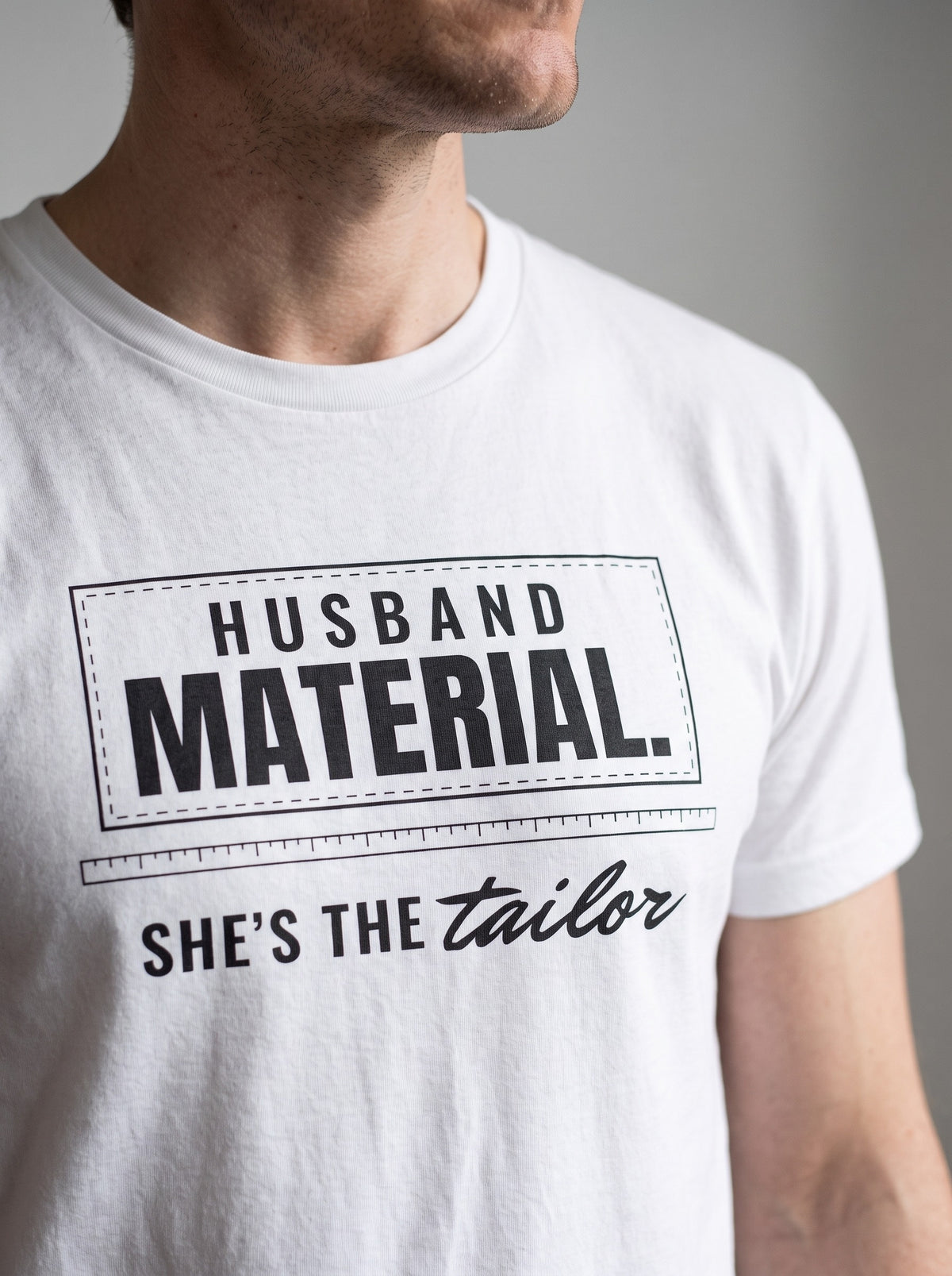 Husband Material. She's the Tailor. tee in White — angled close-up [kk-studio]
