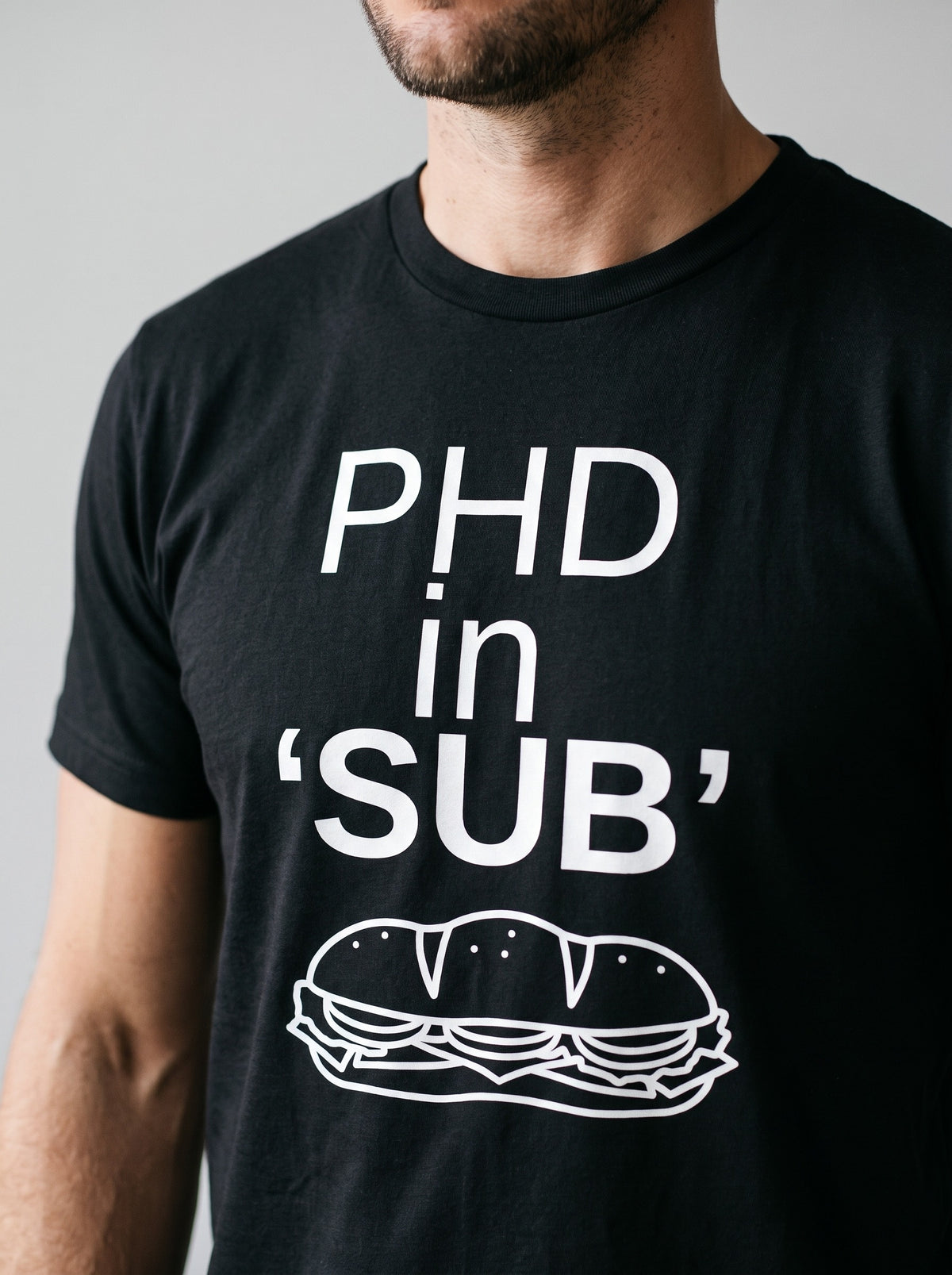 PhD in Sub tee in Black — angled close-up [kk-studio]